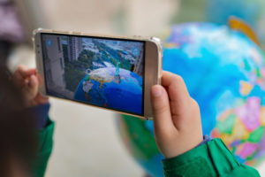 A child seeing the globe come to life on a smartphone.