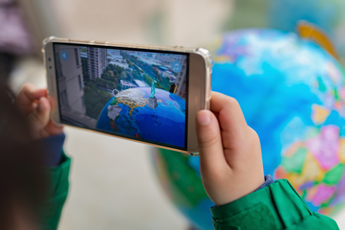 A child seeing the globe come to life on a smartphone.