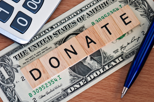 The word donate spelled out on a dollar bill to represent classroom trends receiving donations.