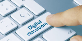 A finger hovers over a keyboard key labeled digital classroom.