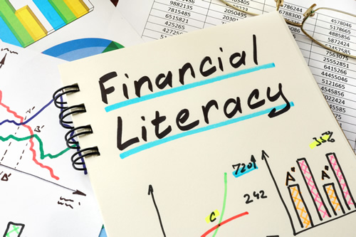 the words Financial Literacy written on a notebook with bar charts and other financial images