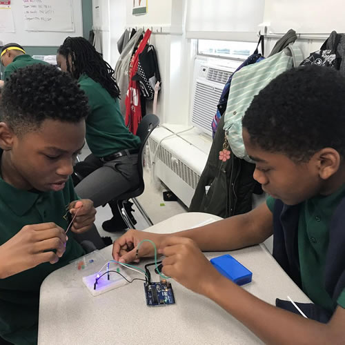 Two students at DPA building a robot