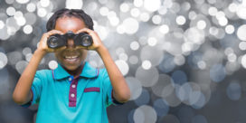 A young student looks through binoculars to illustrate the future and career exploration.