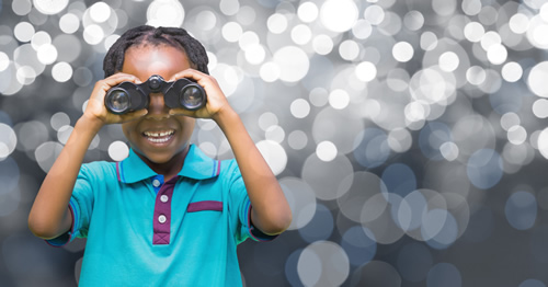 A young student looks through binoculars to illustrate the future and career exploration.
