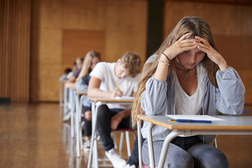 A stressed-out student is taking a test, showing how school avoidance is actually anxiety.