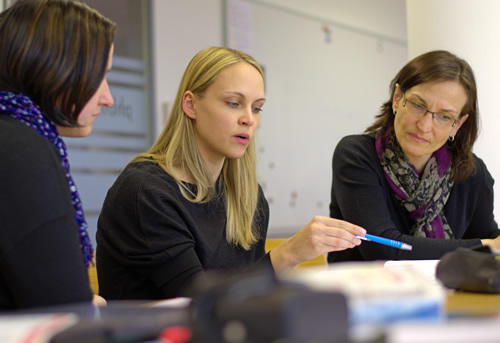 Three women sit and discuss what they're learning in a teacher preparation program.