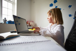 A student using a laptop at home shows why a student safety platform is important for schools.