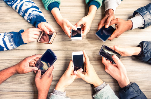 Digital teaching and learning is different in the smartphone era--this circle of hands holding smartphones illustrates connectedness.