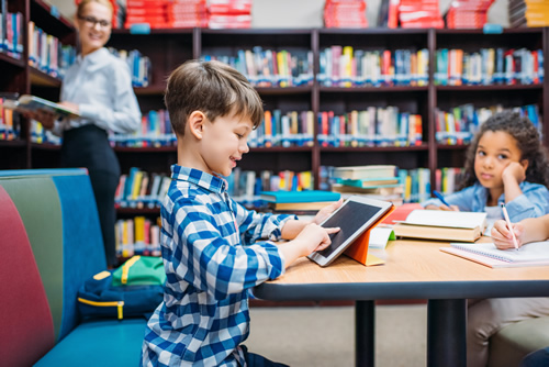 Students have come to expect learning tools that are engaging and easy to use--here are 10 digital and mobile learning tools to try in your classroom, like this student using a tablet in the library.