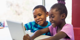 In this district, an early literacy initiative helped improve foundational reading in K-2 students, like these two students reading on a tablet.