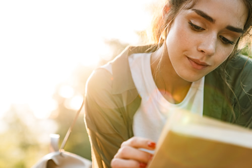Learn how to maximize learning and help elevate students to reading proficiency, like this girl sitting and reading a book.