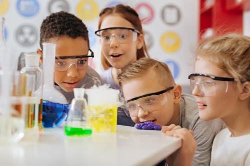 Challenge-Based Learning helps students with their science exploration, like these young students excited about a science experiment in class.