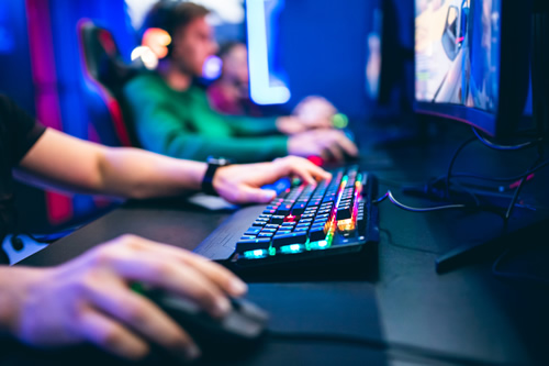 Esports is growing in school districts across the nation, evidenced by this gamer playing a competitive esports game with a glowing keyboard.