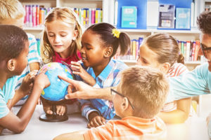 Young students gather with a teacher and learn, as the school's centralized LMS supports UDL.