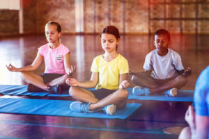 Students are better able to focus when they have time for movement and learning--and these strategies can be used at home while schools are closed, like these kids in yoga class.