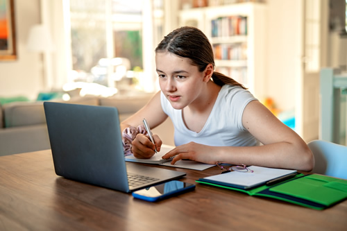Educators can turn to a number of online resources to better connect with their students, like this happy girl student on her computer during distance learning.